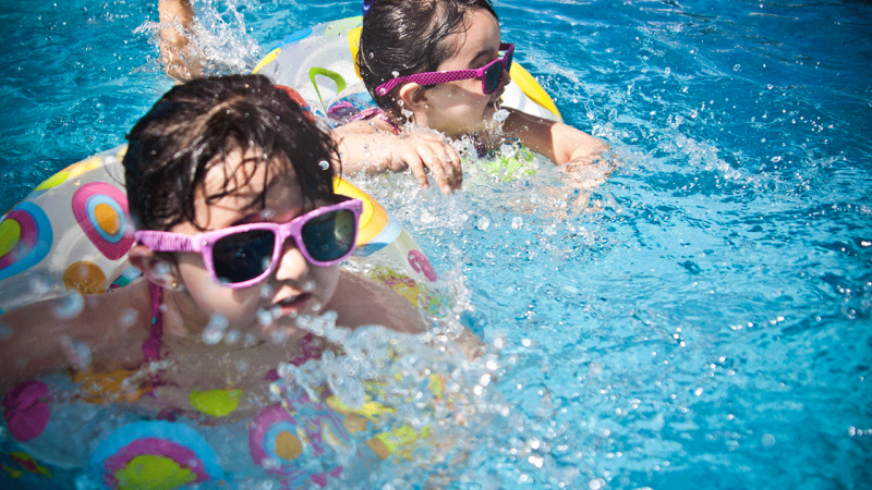 Crianças na piscina do seu destino de férias